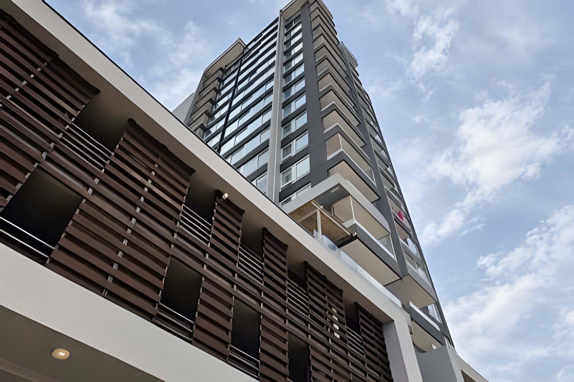 A modern building with a prominent corner design, featuring a mix of glass and metal elements.