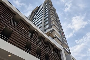 A modern building with a prominent corner design, featuring a mix of glass and metal elements. - Vista al mar - Estudio para 3 personas (Coquimbo)