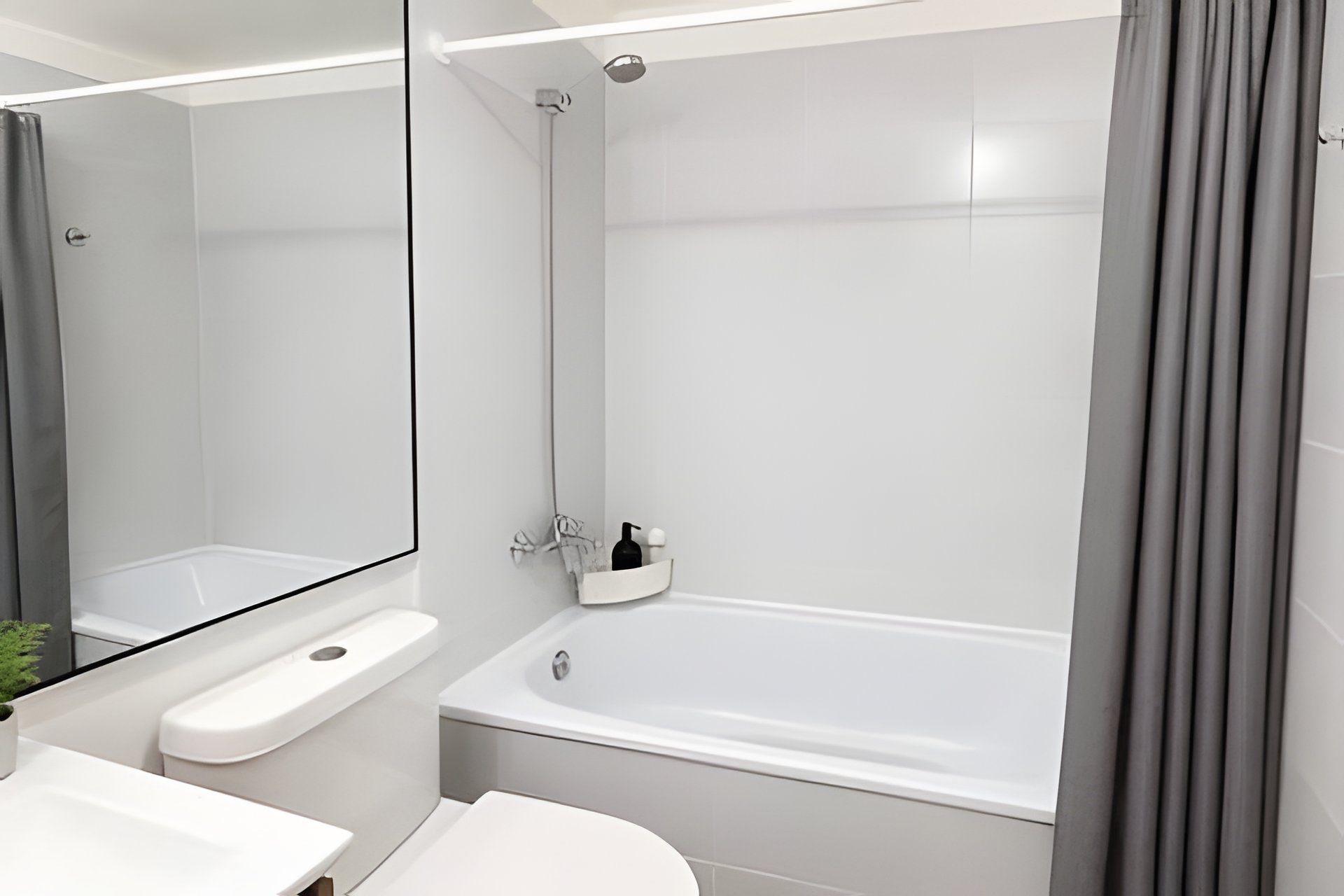 Un baño moderno con bañera, lavabo y espejo.