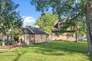A residential property with a well-maintained lawn, a detached garage, and a house with a gabled roof. - Mayo Clinic Cottage - Power Bed & Recliners (Rochester)