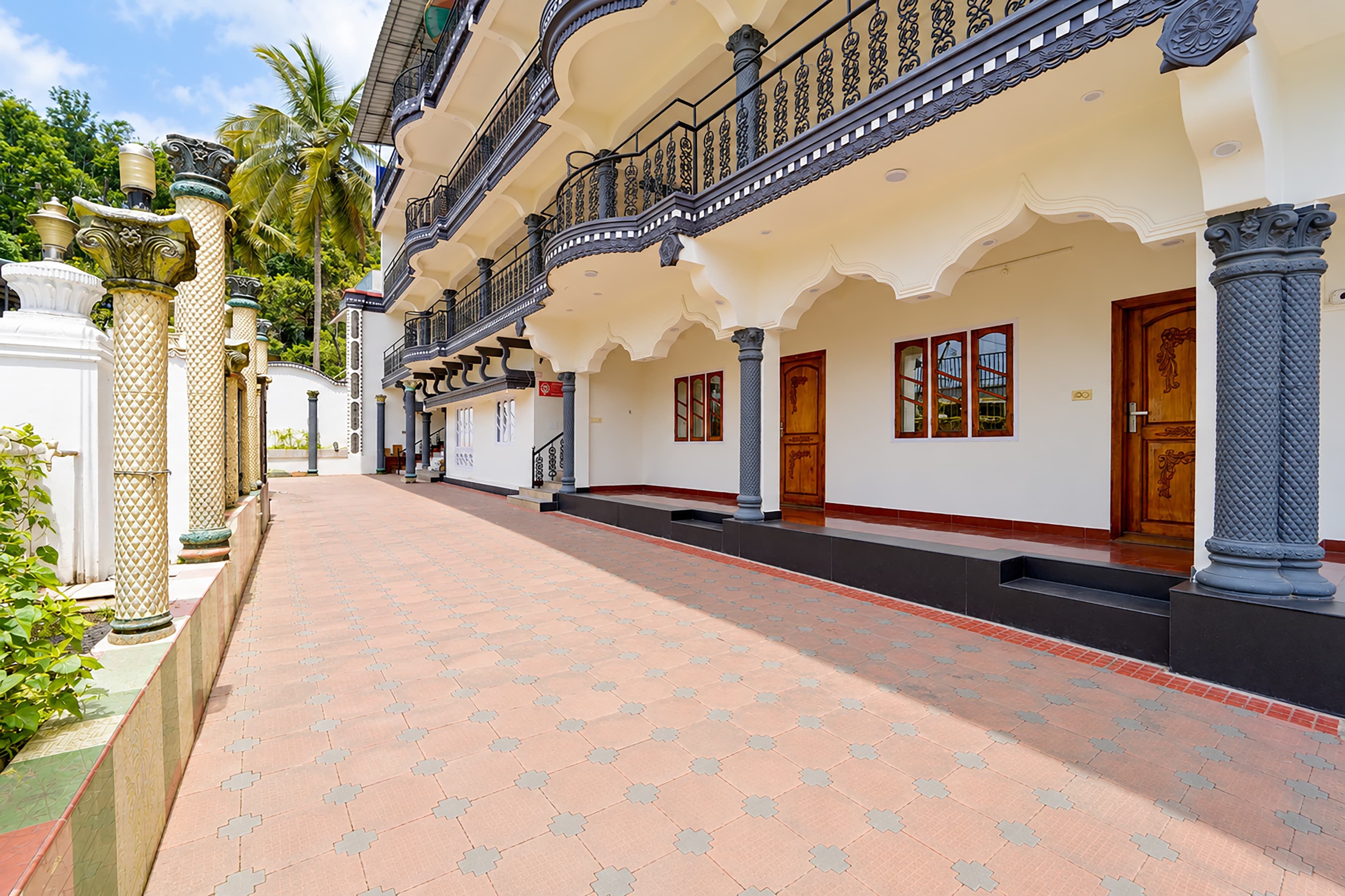 A building with a covered walkway, columns, and a staircase.