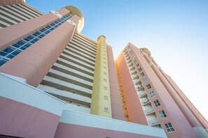 Ein mehrstöckiges Gebäude mit modernem architektonischen Design, das eine Reihe von Balkonen und eine markante zentrale Säule aufweist.
