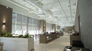 A spacious hotel lobby with a central island, large windows, and a high ceiling with exposed ductwork. - remainzhotel (Incheon)
