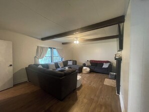 A living room with a sectional sofa, a coffee table, and a window with curtains. - Private 2-bedroom house in Bloomington (Bloomington)