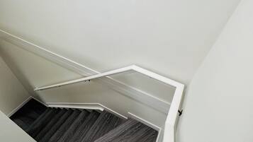 A staircase with a wooden floor and white walls.