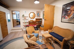 A living room with wicker furniture, a coffee table, and a bookshelf. - Charming 5-bedroom house in South Lake Tahoe perfect for families (South Lake Tahoe)