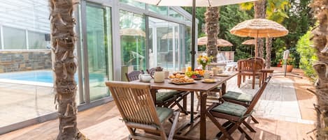 An outdoor dining area with a table, chairs, and umbrellas.