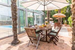 An outdoor dining area with a table, chairs, and umbrellas. - Paradise Forest Glamping near Koper Hut 1, Koper, Slovenia (Koper)