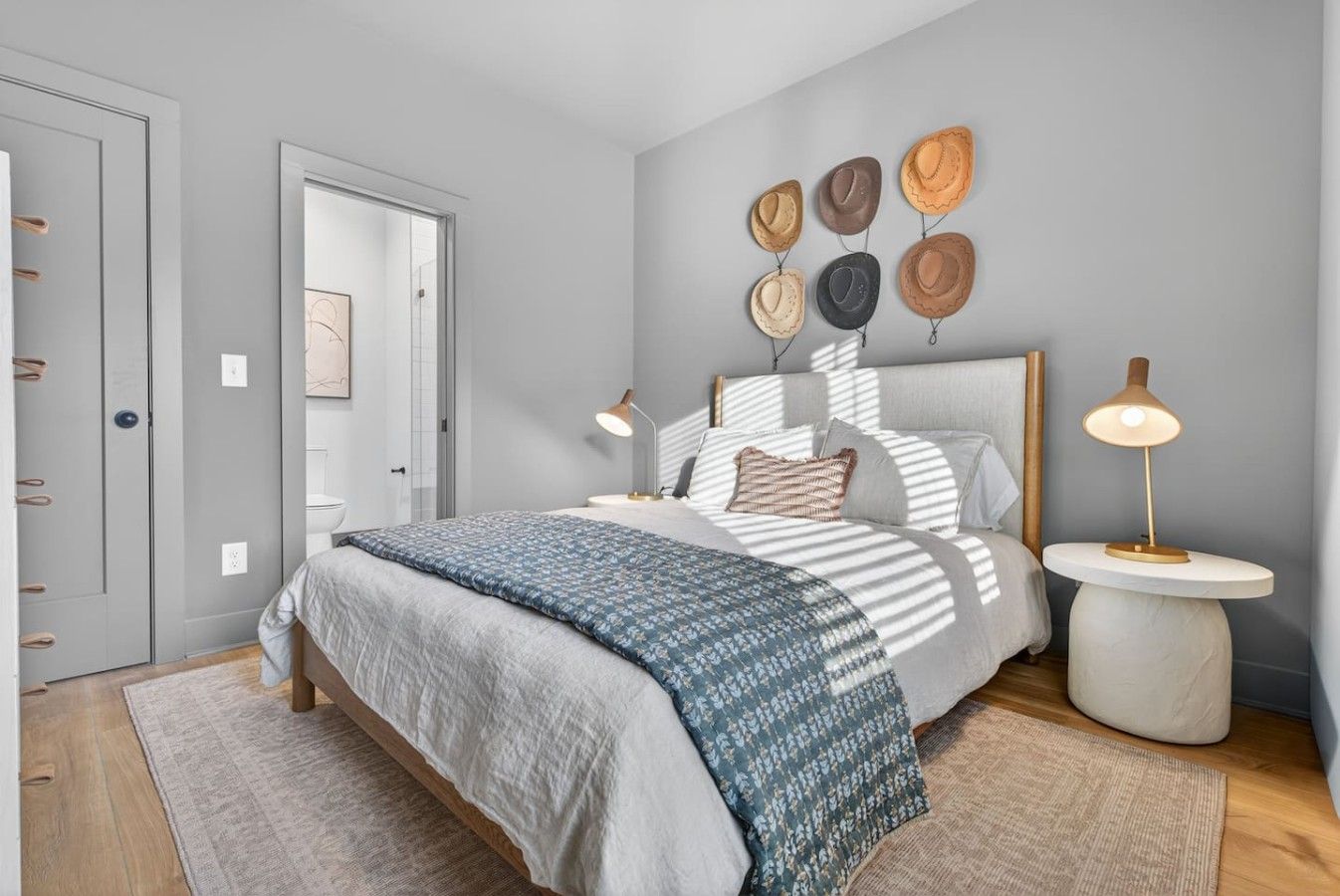 A modern bedroom with a bed, bedside tables, and wall-mounted decor.