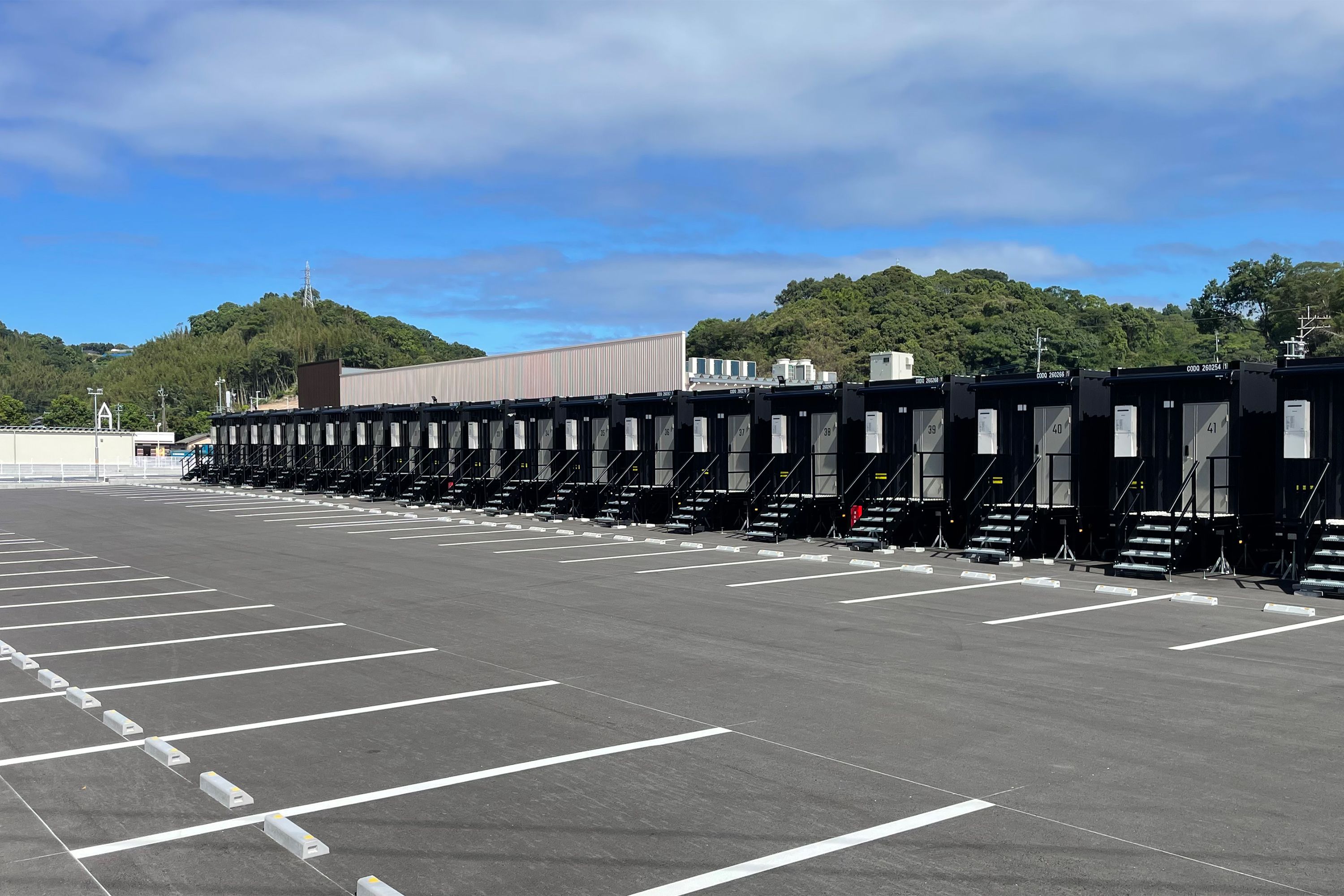 A parking lot with rows of black portable toilets.