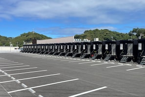Een parkeerplaats met rijen zwarte mobiele toiletten.
