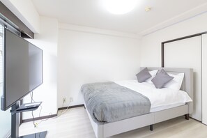 A modern bedroom with a bed, a flat-screen TV, and a desk with a computer. - Ocean Imamiyaebisu Ekimae (Osaka)
