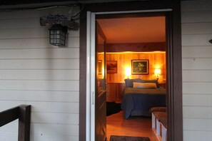A wooden interior with a bed, bedside lamps, and a painting on the wall. - Unique 3-bedroom home in charming Carnelian Bay-North Lake Tahoe, CA (Carnelian Bay)
