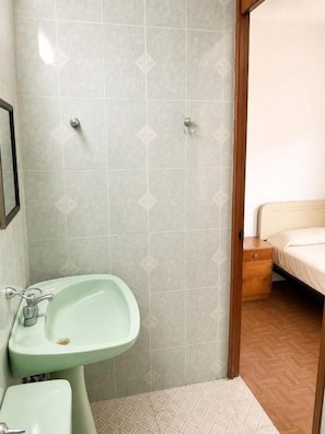 A bathroom with a sink, toilet, and shower area. - hotel bartolome (Oaxaca)