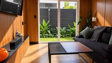 A modern living room with a sofa, coffee table, and a TV mounted on the wall.