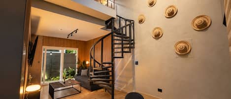 A modern interior with a staircase, a dining area, and a living space.