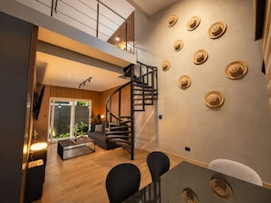 Un interior modern amb una escala, una zona de dinar i un espai de menjador.