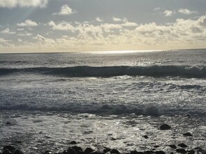 Ein Strand mit Wellen und blauem Himmel.