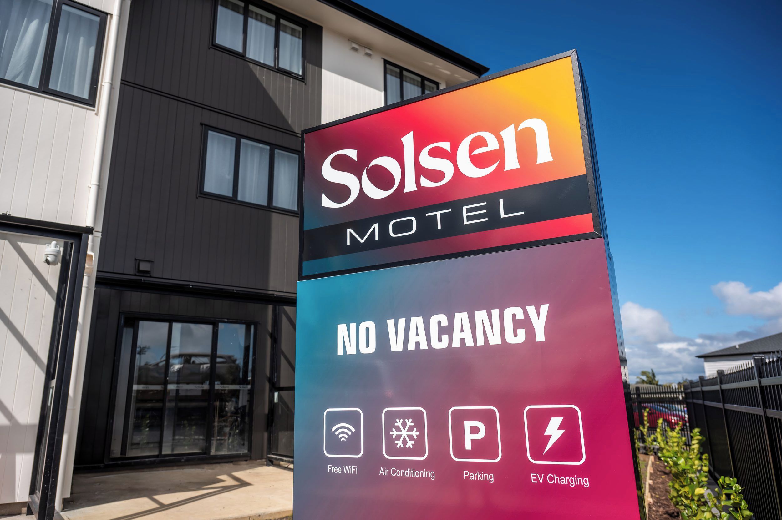 Señal del motel Solsen con servicios que incluyen WiFi gratuito, aire acondicionado, estacionamiento y carga para vehículos eléctricos.