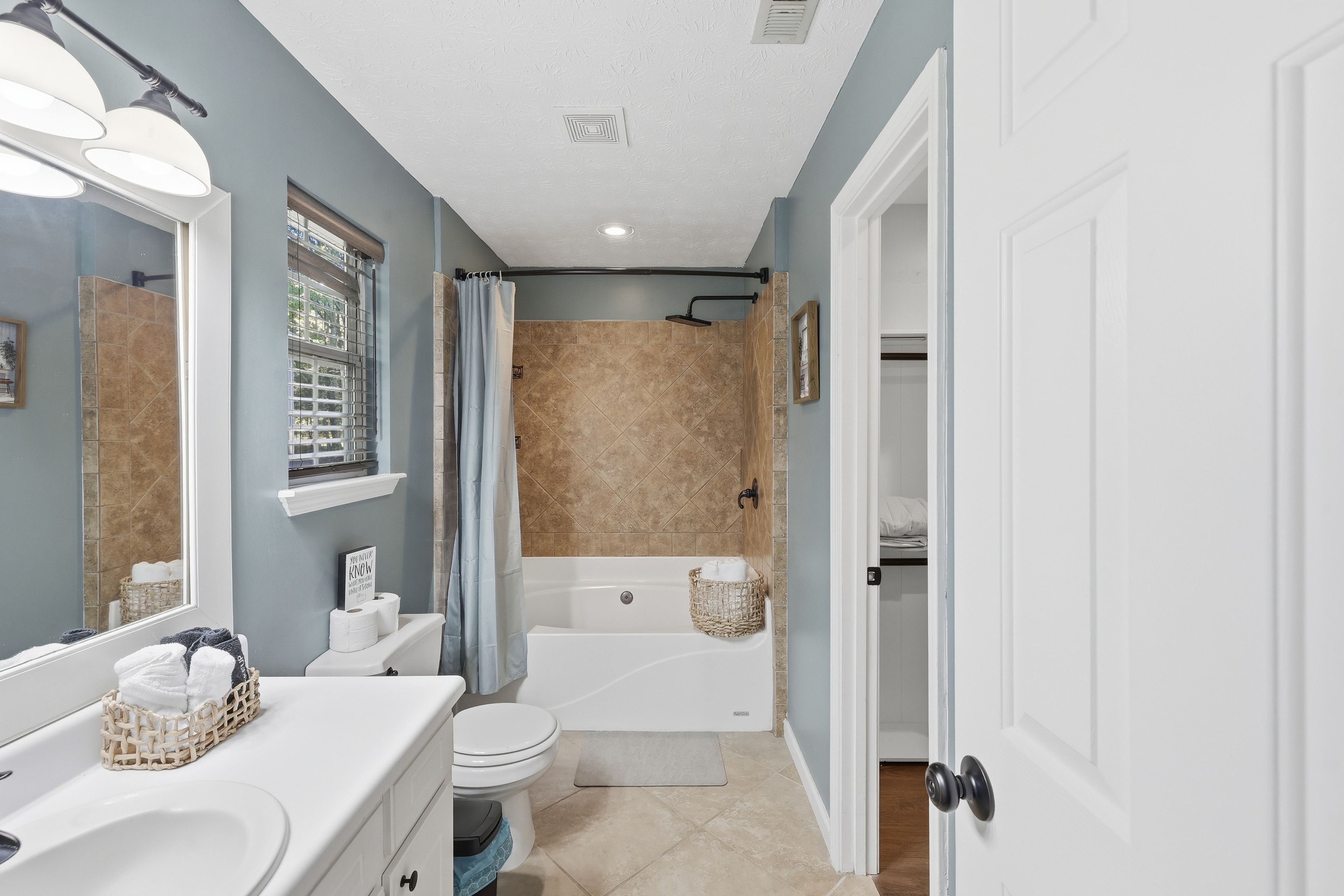 A bathroom with a shower, toilet, and sink.