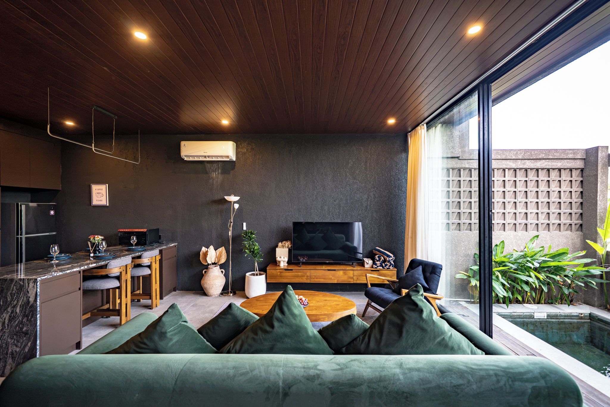 Una sala moderna con sofá, televisor y zona de comedor.