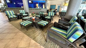 A hotel lobby with wicker furniture, a reception desk, and a television screen. - Heart of Waikiki! 5 minutes to beach, Kitchenette, Two Beds, Sofa Bed (Honolulu)
