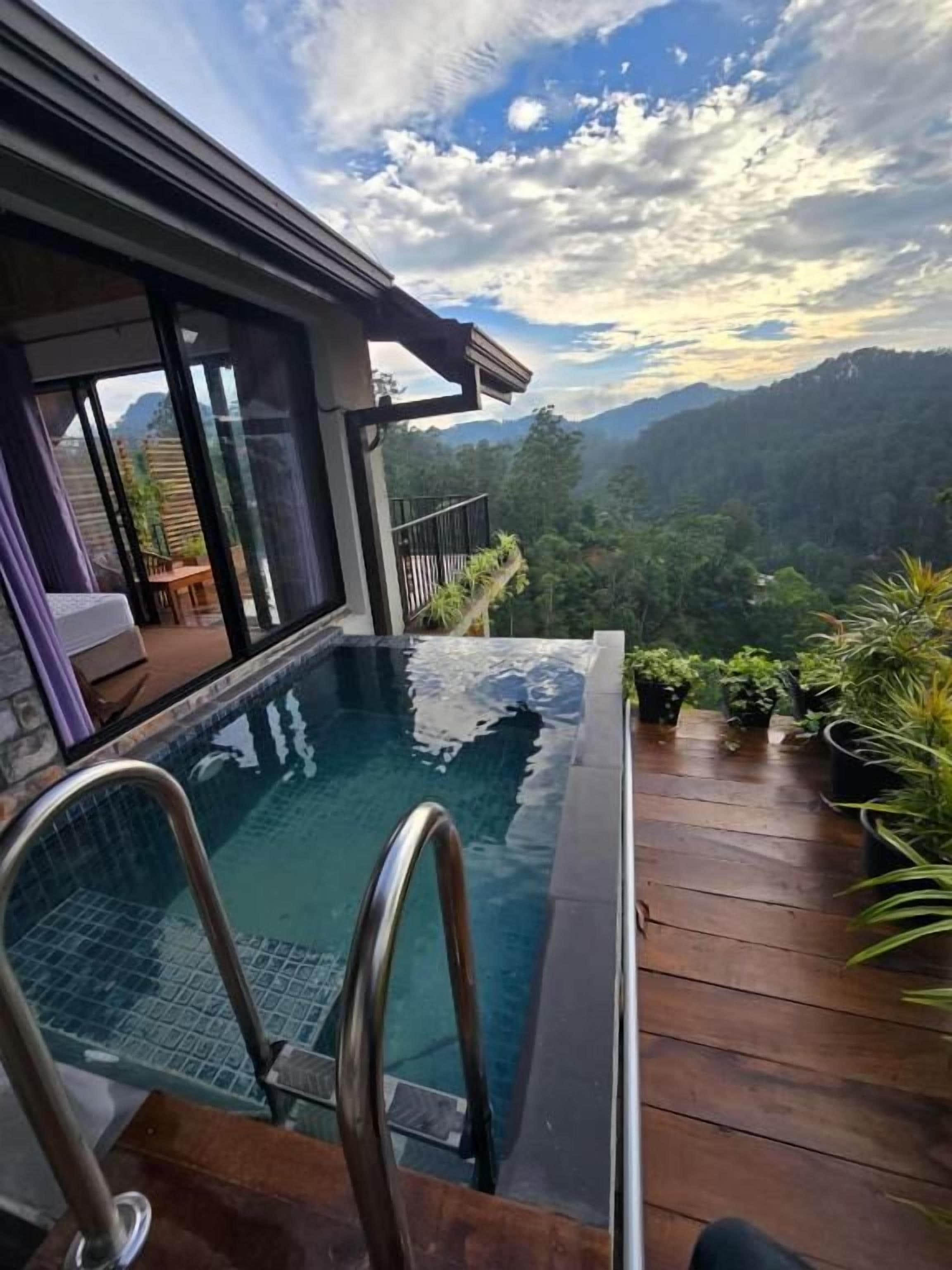 Piscina con cubierta de madera y vista a un paisaje montañoso.
