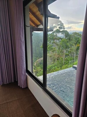 Una habitación con un ventanal grande con vistas a un paisaje montañoso.