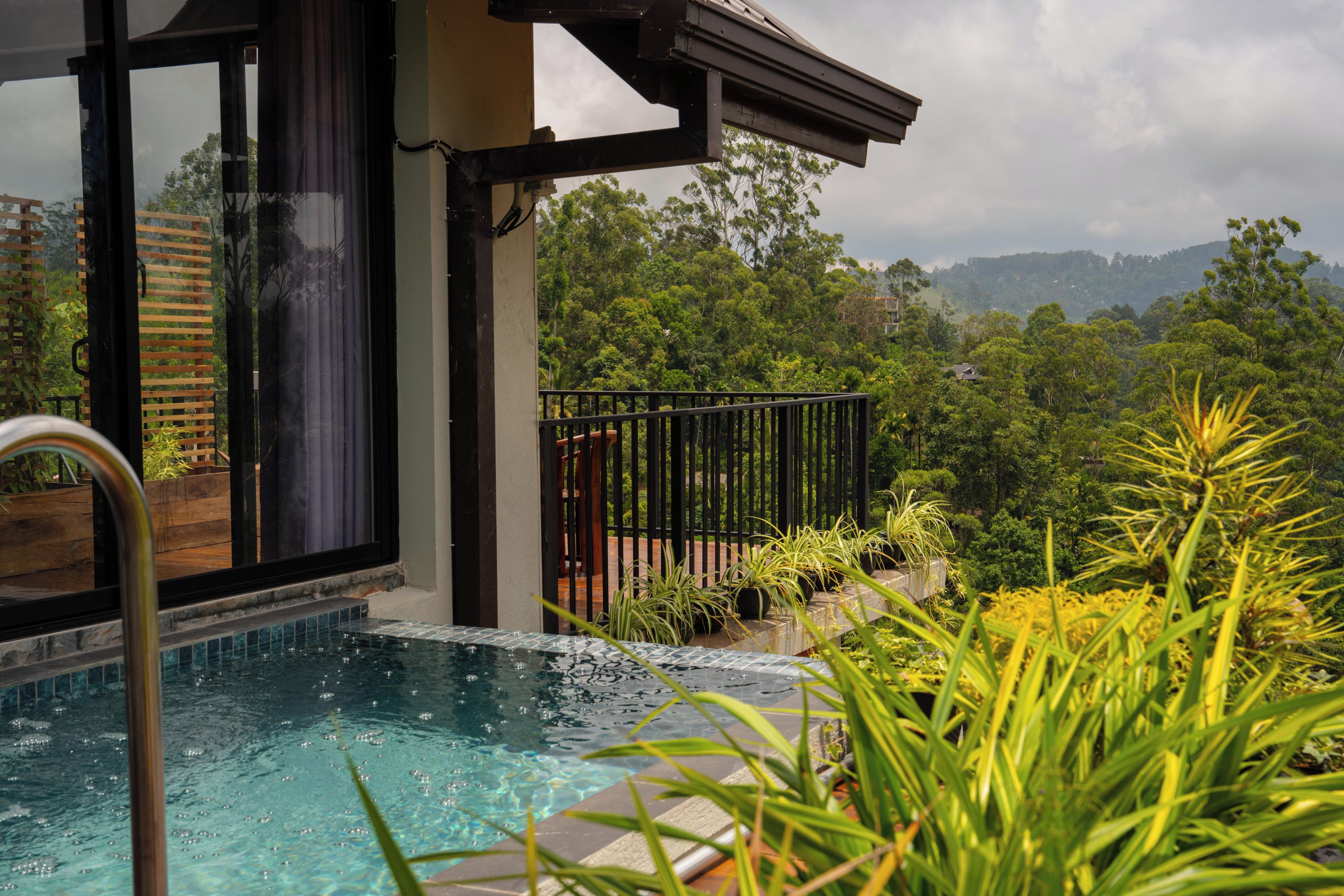 A swimming pool with a view of a forested landscape.