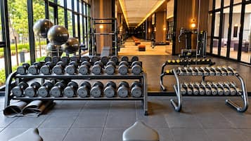 A gym with weightlifting equipment, benches, and dumbbells.