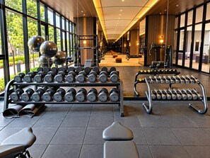 A gym with weightlifting equipment, benches, and dumbbells. - Skyline Embassy KLCC By Skyblue Suites (Kuala Lumpur)