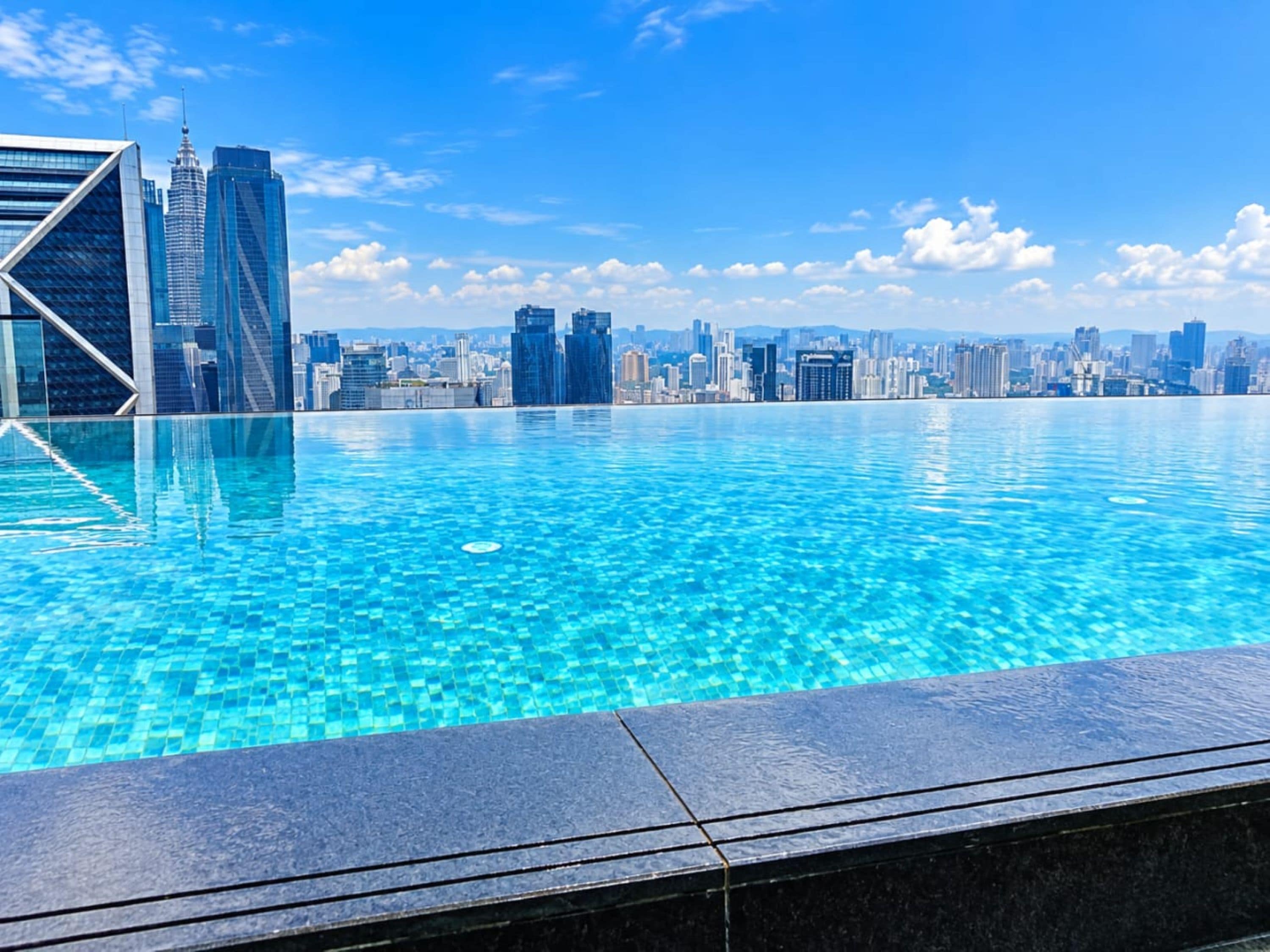 A swimming pool with a city skyline in the background.