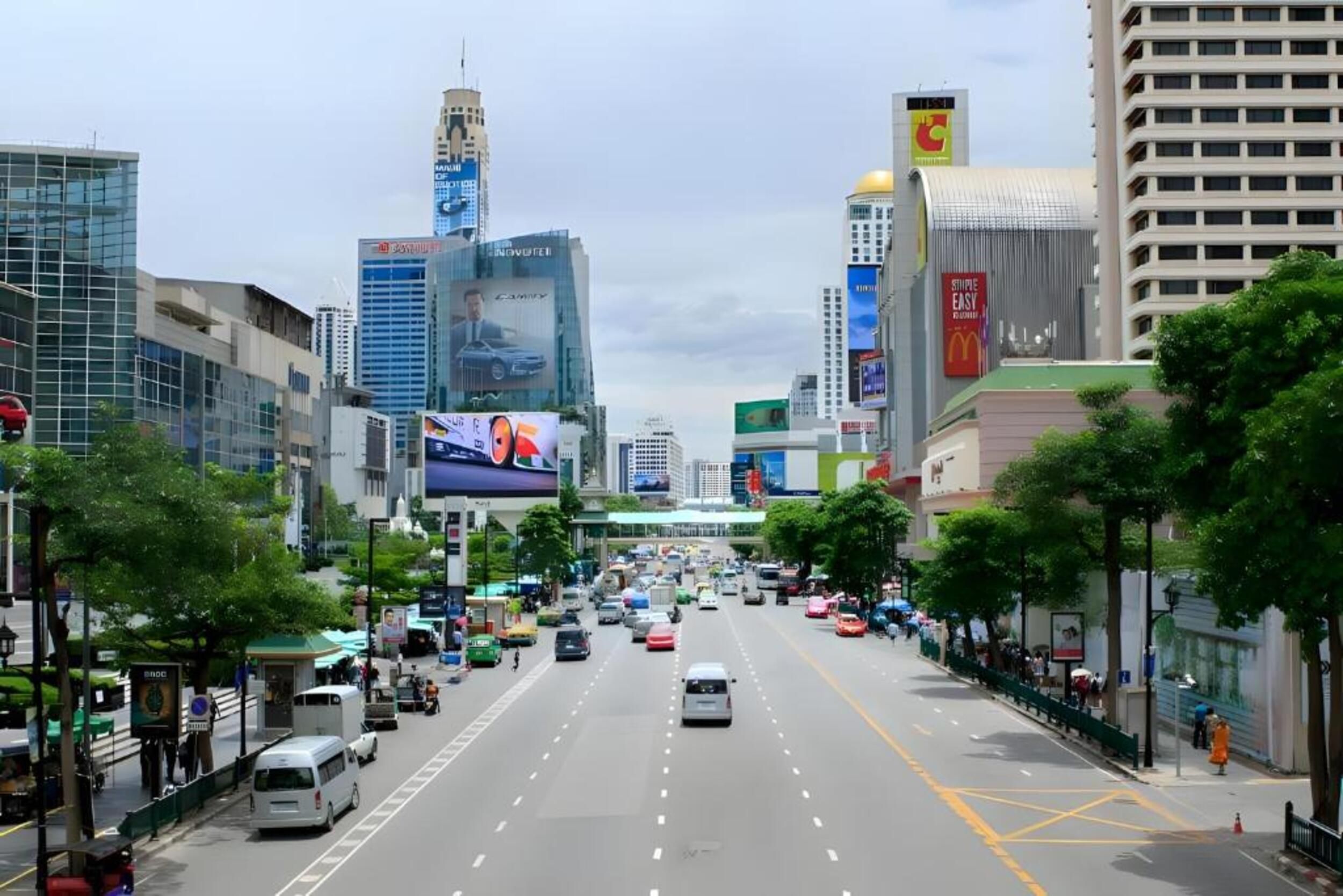 A busy urban street lined with modern buildings and billboards.