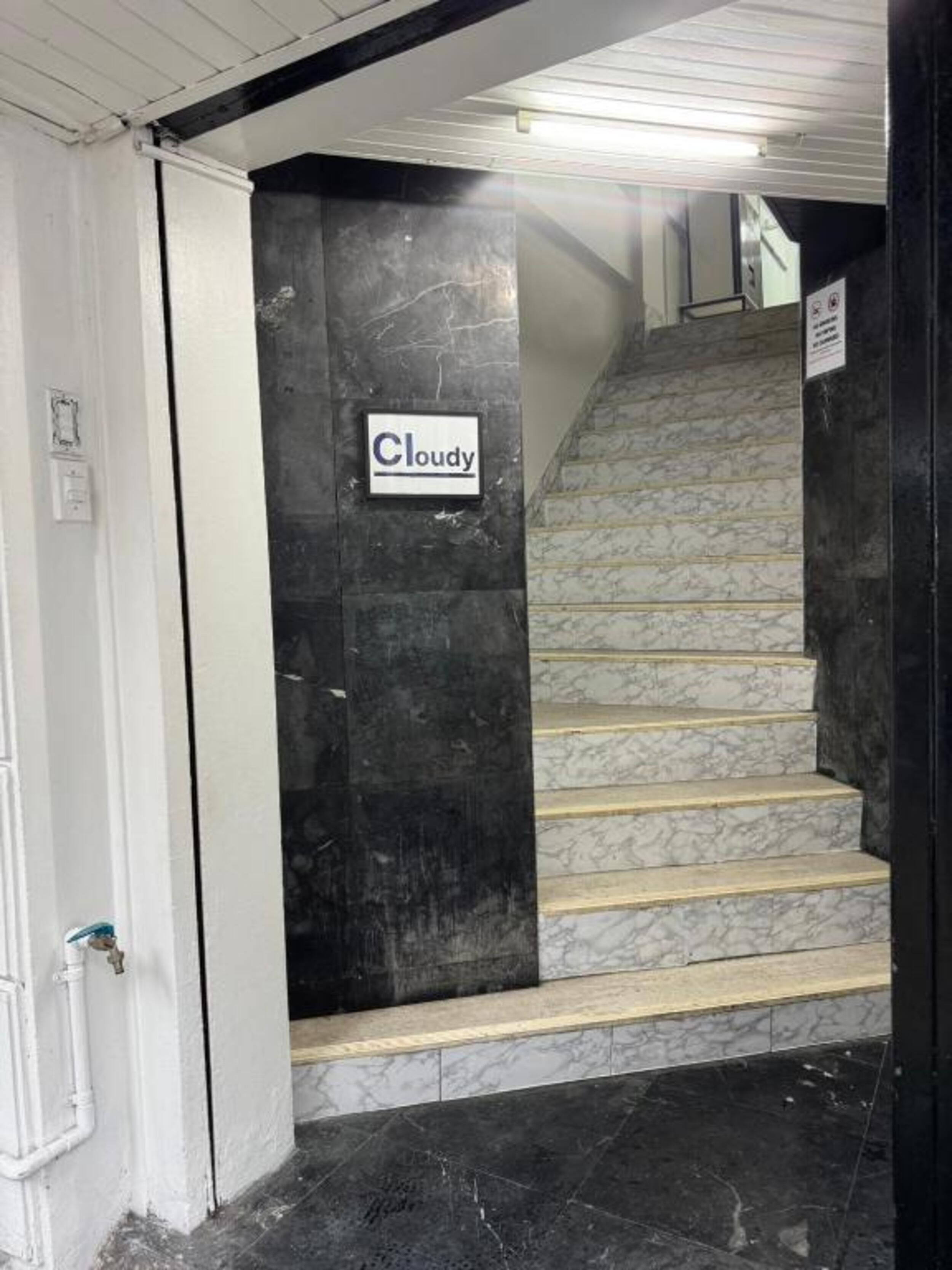 A staircase with marble steps and a sign that reads 'Cloudy'.