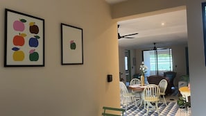 Ein Essbereich mit Tisch und Stühlen, einem Deckenventilator und Blick ins Freie.