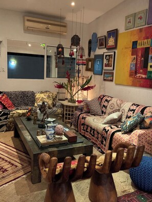 Una sala de estar con un sofá, una mesa de centro y adornos decorativos.