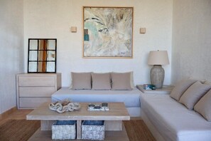 Ein modernes Wohnzimmer mit einer Couch, einem Couchtisch und einem Gemälde an der Wand.