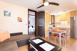 A modern apartment with a living area, kitchenette, and a dining space. - Cozy apartment with a terrace and pool in sunny southern Tenerife (Costa Adeje)