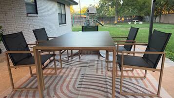 An outdoor patio with a rectangular table and four chairs.