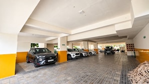 Un parking à plusieurs niveaux où sont stationnées plusieurs voitures.