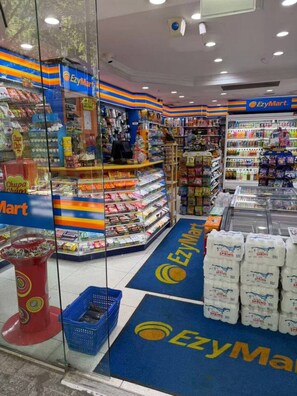 A grocery store interior with shelves stocked with various products, a refrigerated section, and a checkout area. - City Stay in Brisbane | Modern 2BR with Pool & Gym (Brisbane City)