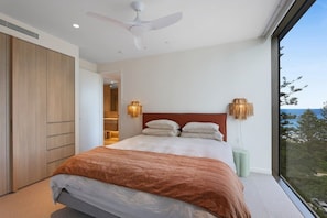 A bedroom with a bed, a ceiling fan, a view of the outdoors, and a wardrobe. - The Burleigh Coastal Luxe (Gold Coast)