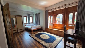 A bedroom with a bed, a desk, a chair, a wardrobe, and a window with curtains. - Traditional 3-Bedroom Apartment Near Patan Square (Lalitpur)
