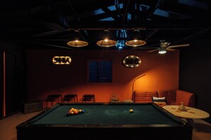 A pool table with balls, a sofa, and a table with a glass and a bottle. - Pool, Hot Tub & Sauna - 5 Min to Joshua Tree NP & Downtown- Epic Views (Joshua Tree)