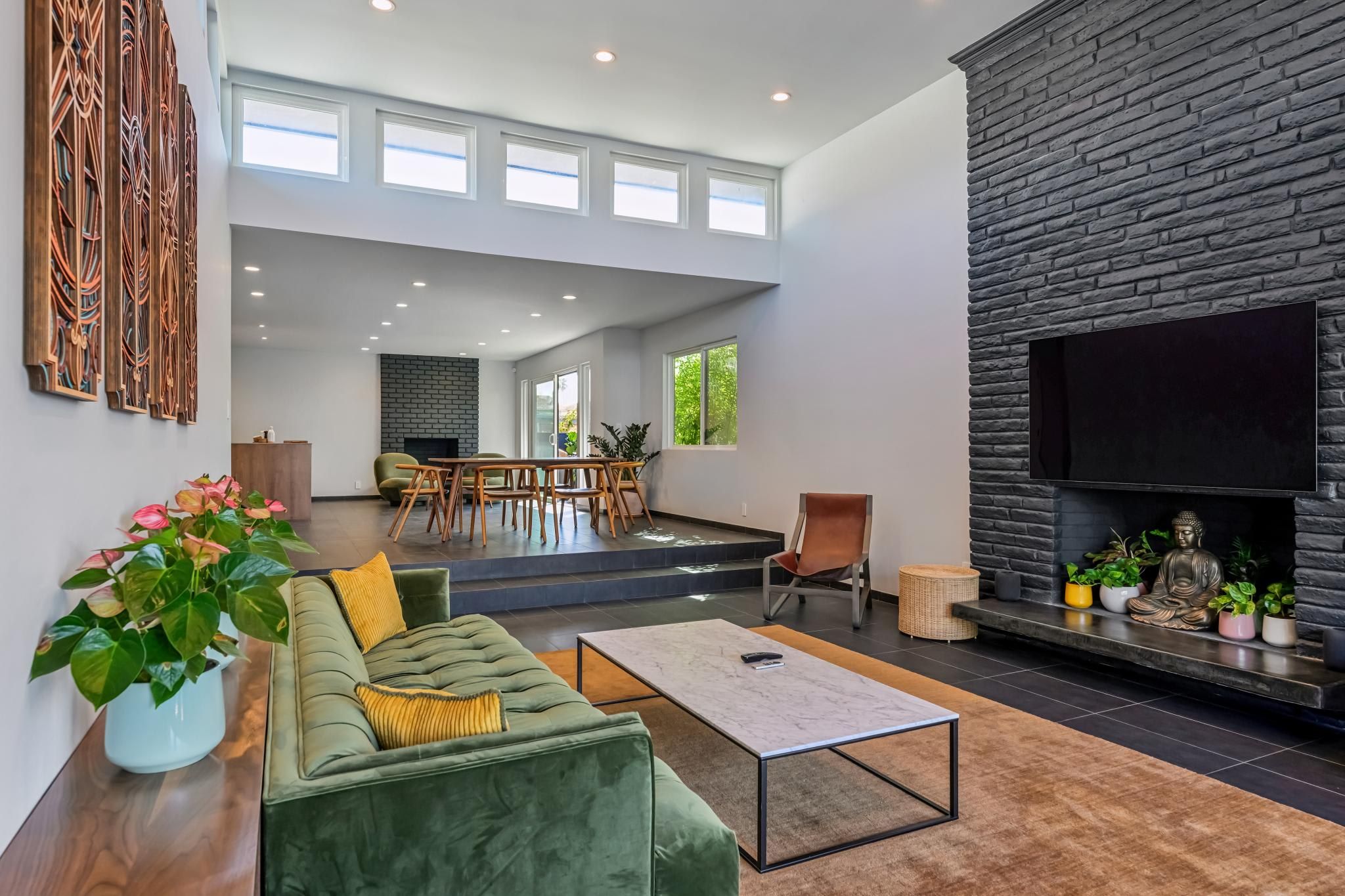 Un amplio salón con un sofá verde, una mesa de centro y una chimenea.