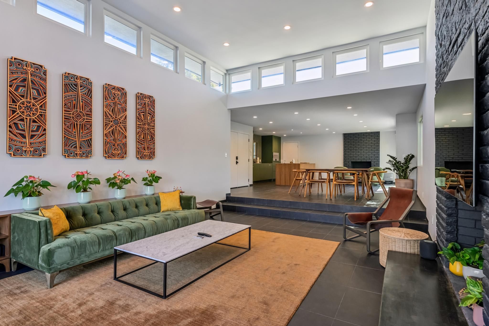 A spacious living area with a green sofa, a coffee table, and decorative wall art.