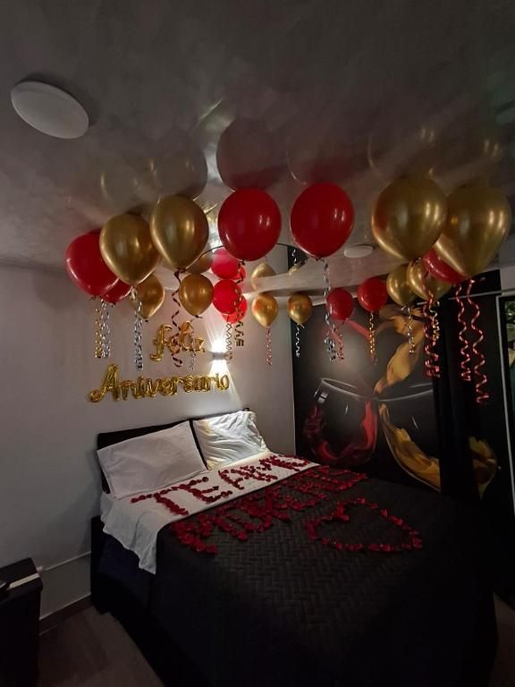 Een slaapkamer met een bed, een wanddecoratie en ballonnen.