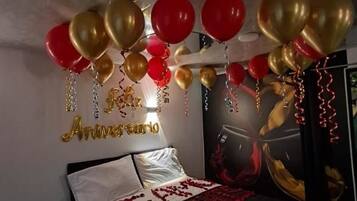 Een slaapkamer met een bed, een wanddecoratie en ballonnen.