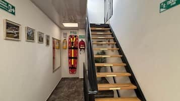Una escalera de madera con barandilla negra que lleva a un piso superior.