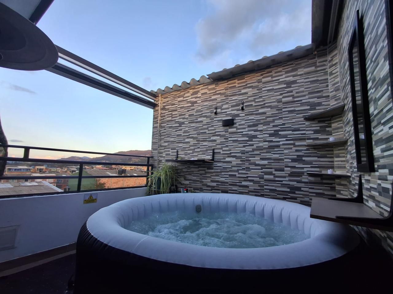 An outdoor hot tub with a view of the cityscape.